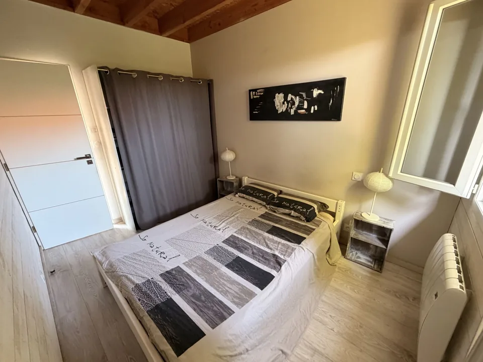 Vue d’ensemble de la chambre double avec rangements et tables de chevet